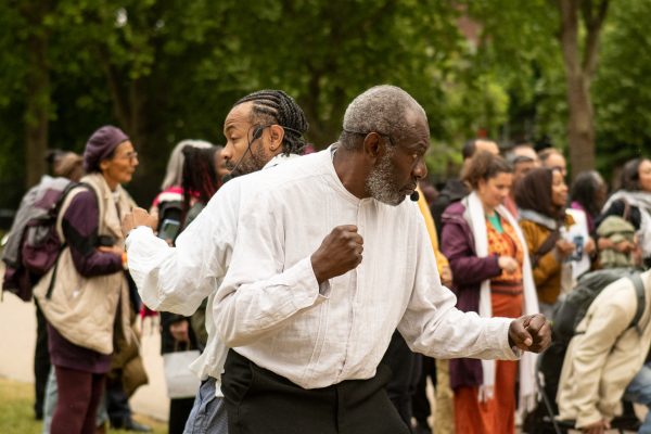 Two actors standing back-to-back, posing like they are fighting